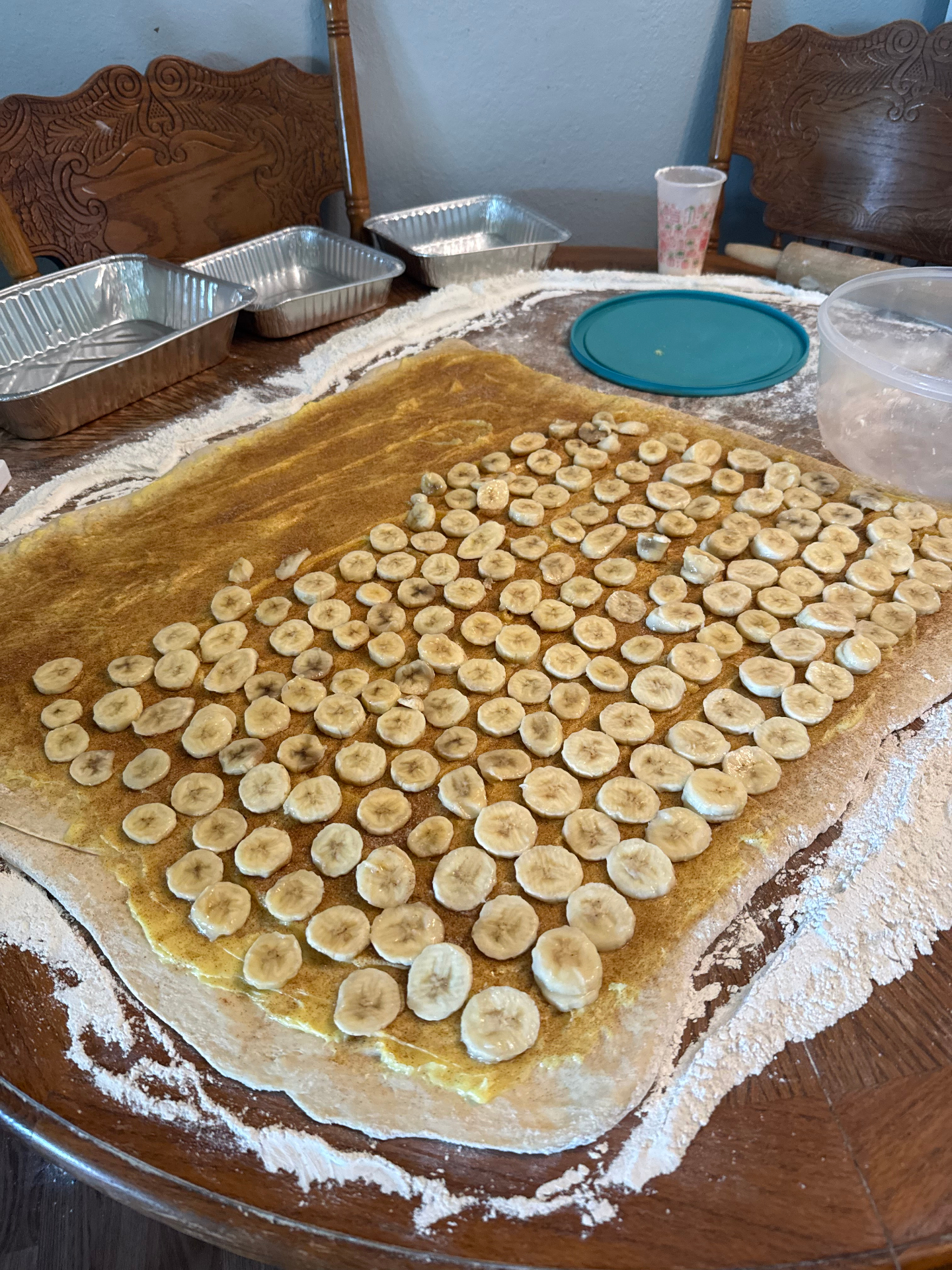 Fresh dough with sliced bananas and cinnamon sugar, ready to roll