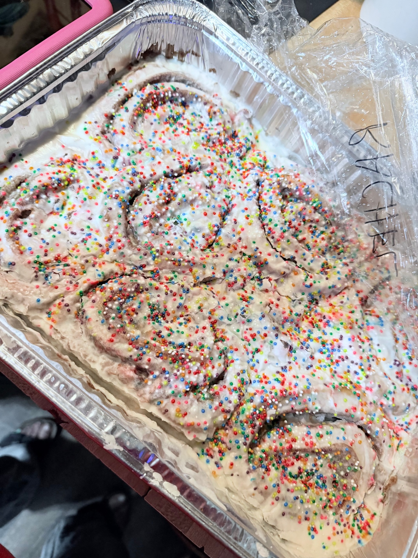 Sweet rolls topped with rainbow sprinkles and vanilla icing